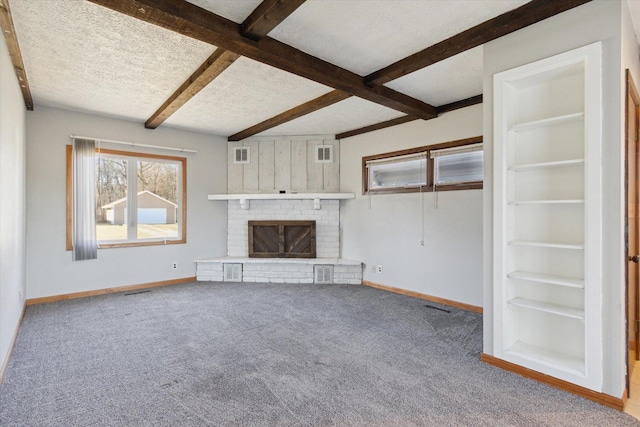 unfurnished living room featuring light carpet, a textured ceiling, beam ceiling, and a brick fireplace