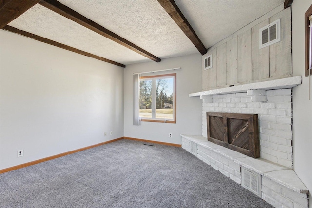 unfurnished living room with a textured ceiling, carpet flooring, beamed ceiling, and a fireplace