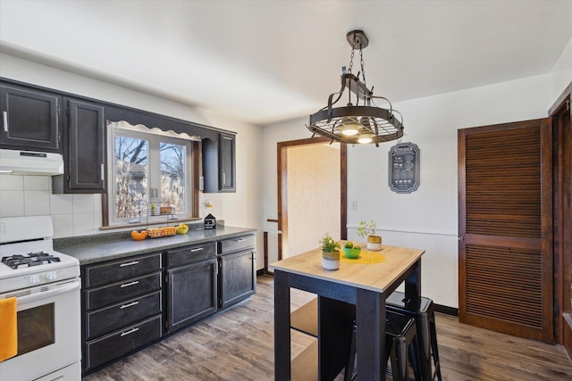 kitchen with white range with gas cooktop, hardwood / wood-style floors, pendant lighting, and decorative backsplash