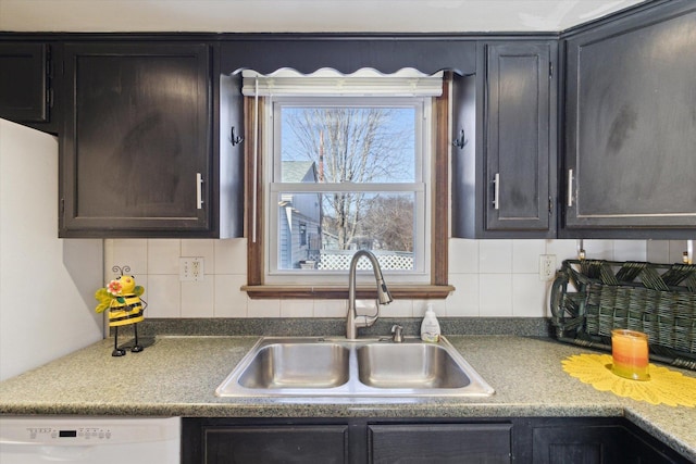 kitchen featuring sink, tasteful backsplash, and white dishwasher