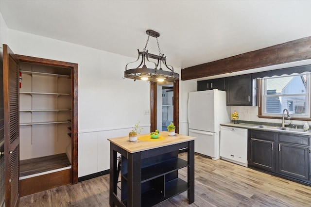 kitchen featuring light hardwood / wood-style floors, sink, white appliances, and hanging light fixtures