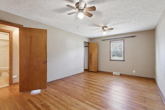 spare room with ceiling fan, a textured ceiling, and light hardwood / wood-style flooring