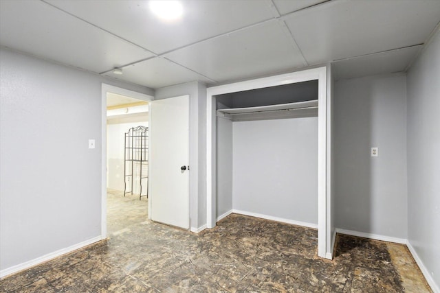 unfurnished bedroom featuring a closet and a drop ceiling