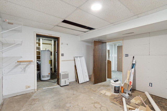 basement featuring a paneled ceiling and water heater