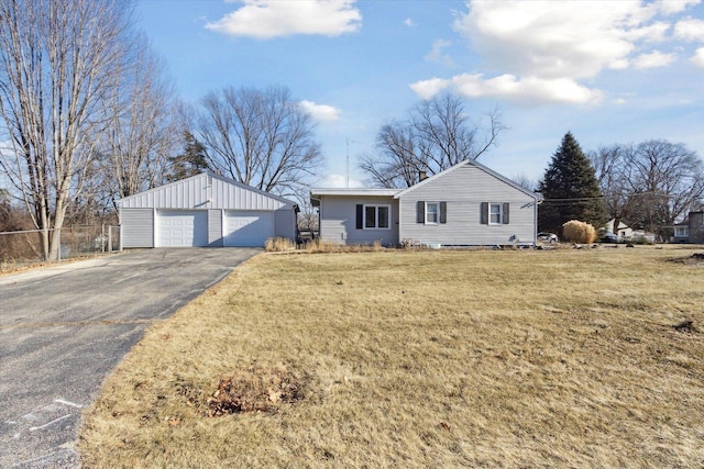 single story home featuring a garage, a front yard, and an outdoor structure