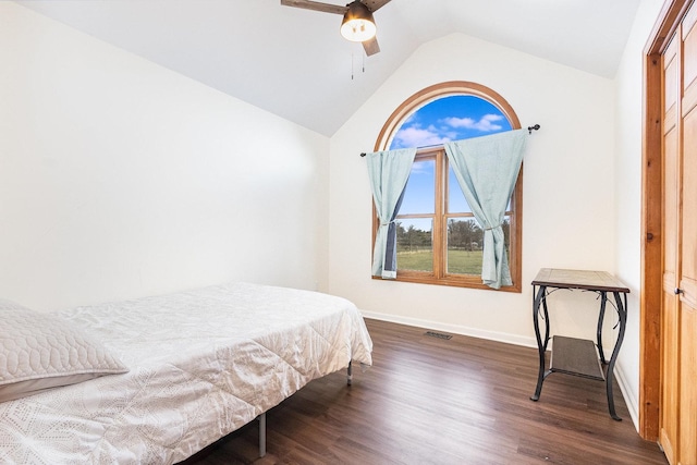 bedroom with ceiling fan, dark hardwood / wood-style floors, a closet, and vaulted ceiling