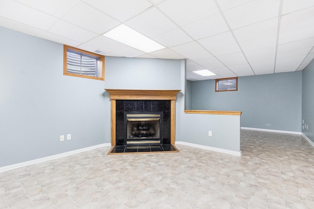 unfurnished living room featuring a paneled ceiling and a fireplace