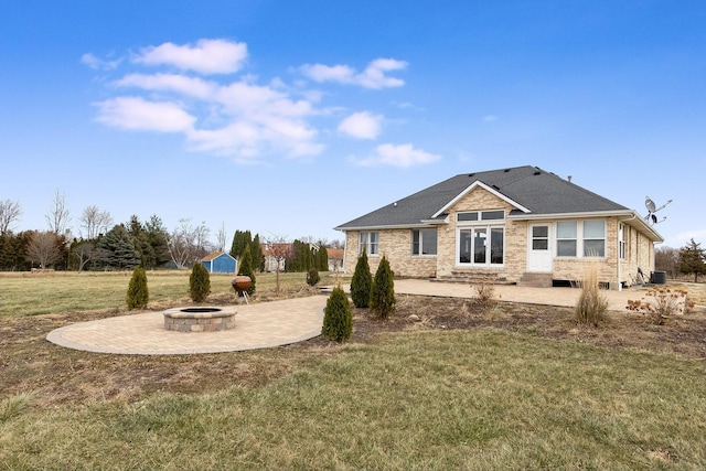 back of property with an outdoor fire pit, a lawn, and a patio