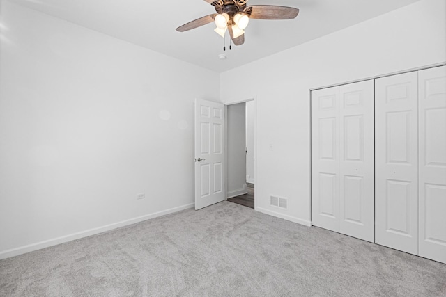 unfurnished bedroom featuring ceiling fan, light carpet, and a closet