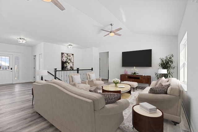 living room with ceiling fan, lofted ceiling, and light wood-type flooring