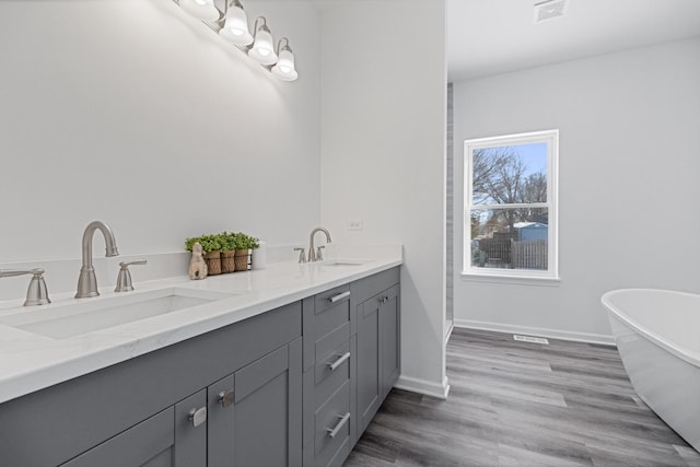 bathroom with vanity, a bathtub, and hardwood / wood-style floors