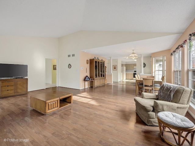 living room with vaulted ceiling and light hardwood / wood-style flooring