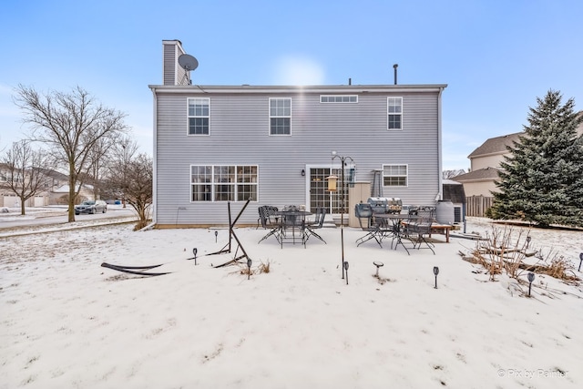 view of snow covered back of property