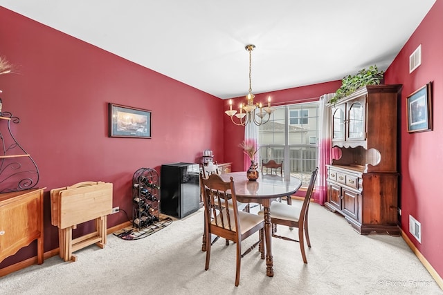 dining space featuring light colored carpet and a chandelier