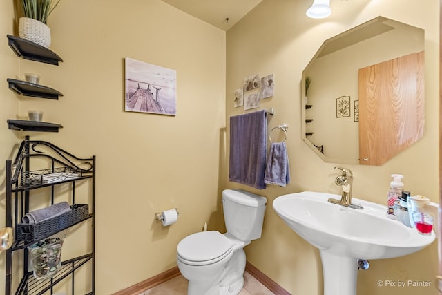 bathroom featuring toilet, tile patterned flooring, and sink