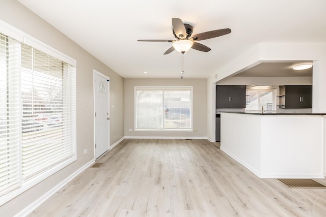 unfurnished living room with ceiling fan and light hardwood / wood-style flooring