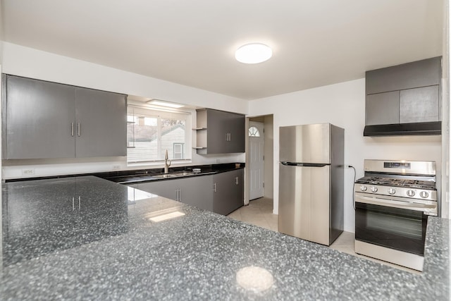 kitchen featuring sink, gray cabinetry, light tile patterned floors, appliances with stainless steel finishes, and dark stone counters