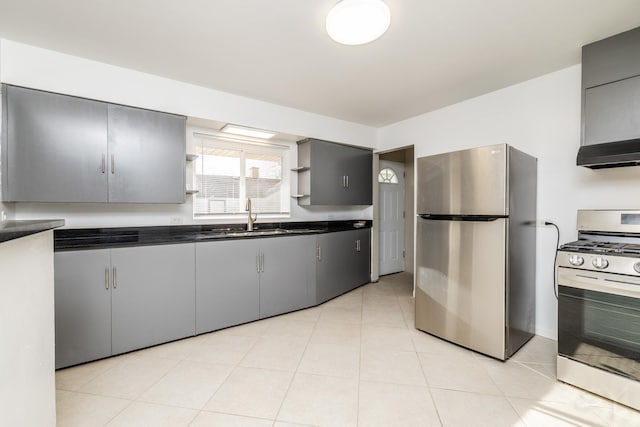 kitchen featuring gray cabinets, appliances with stainless steel finishes, sink, light tile patterned floors, and wall chimney range hood