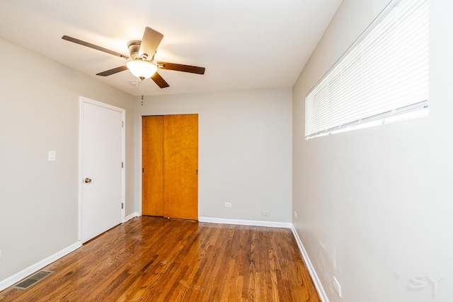 empty room with dark wood-type flooring and ceiling fan