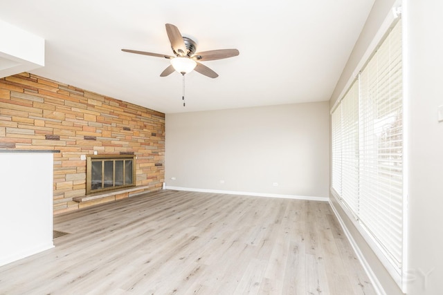 unfurnished living room with ceiling fan, a fireplace, and light hardwood / wood-style flooring