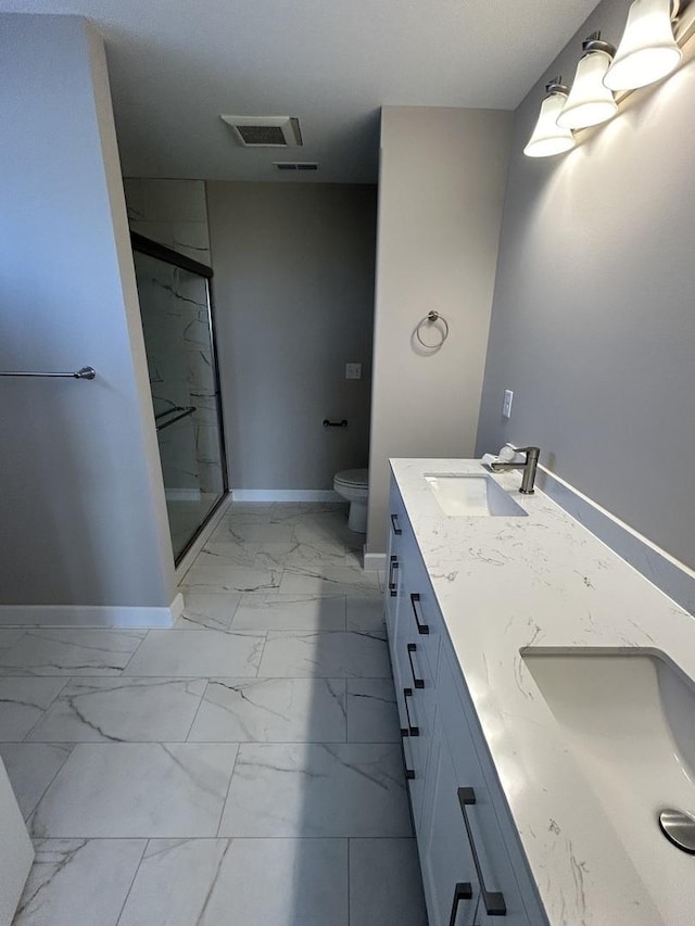 bathroom with vanity, toilet, and a shower with door