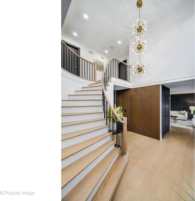 stairs with an inviting chandelier and hardwood / wood-style floors