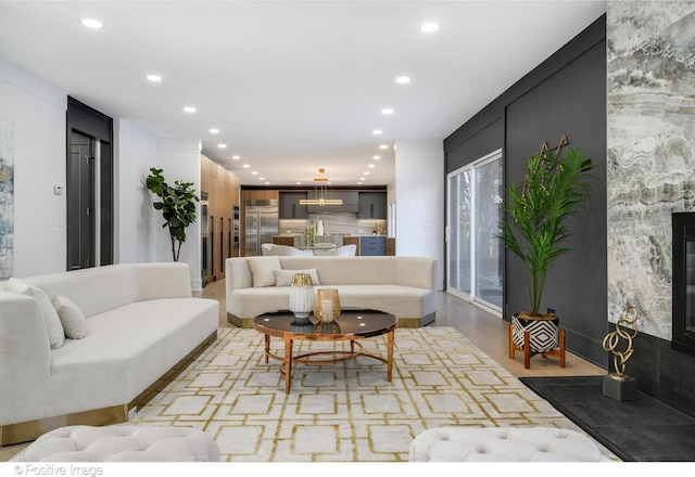 living room featuring a large fireplace and light hardwood / wood-style flooring