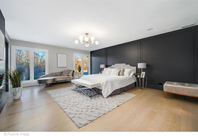 bedroom with ornamental molding, a notable chandelier, and light wood-type flooring