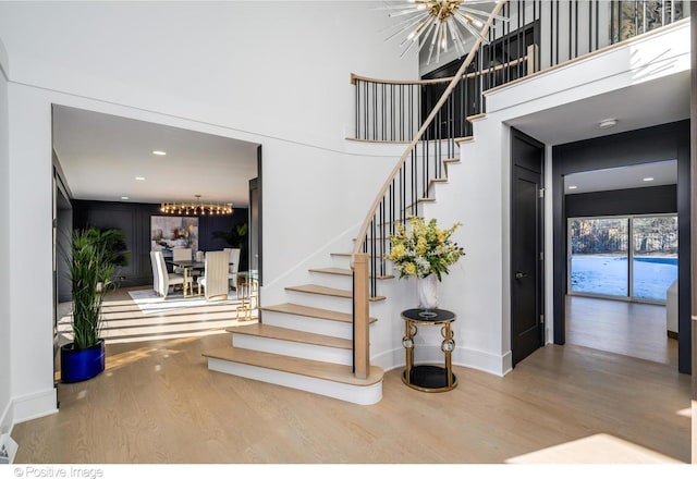 staircase featuring an inviting chandelier and wood-type flooring