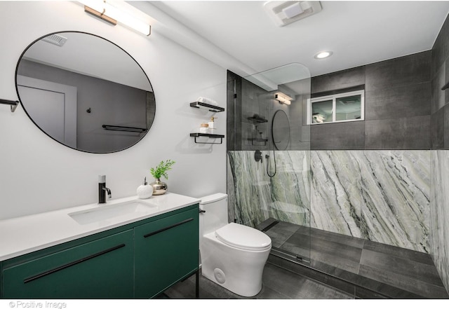 bathroom with toilet, vanity, and a tile shower