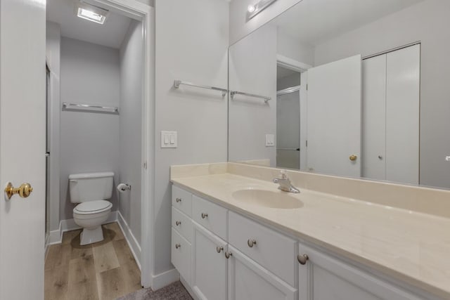 bathroom with vanity, hardwood / wood-style floors, and toilet