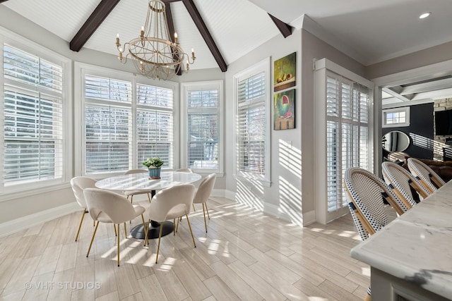 dining room featuring lofted ceiling with beams, a chandelier, and light hardwood / wood-style floors