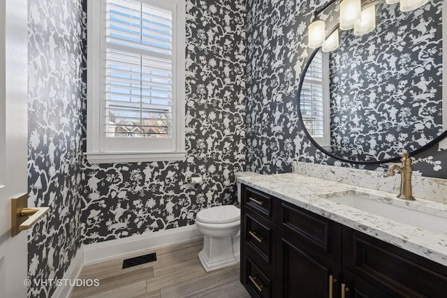 bathroom with vanity, hardwood / wood-style floors, plenty of natural light, and toilet