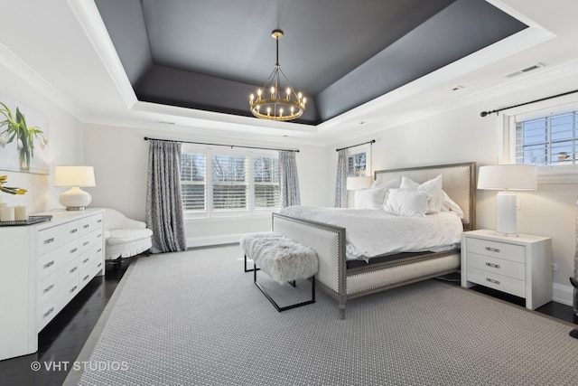 bedroom featuring a raised ceiling, ornamental molding, dark hardwood / wood-style floors, and an inviting chandelier