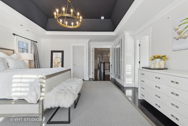 bedroom featuring ornamental molding, dark wood-type flooring, a notable chandelier, and a tray ceiling