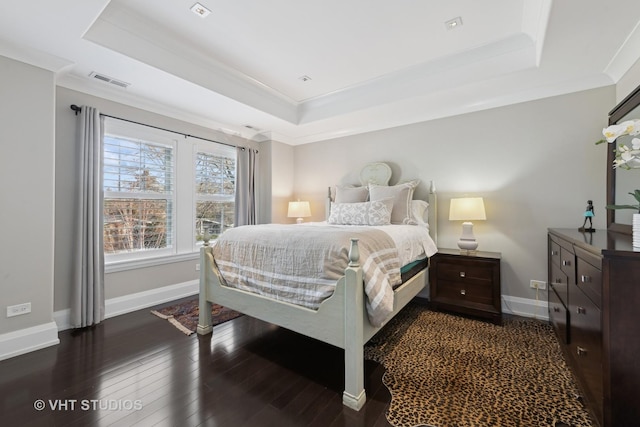 bedroom featuring a raised ceiling, crown molding, and dark wood-type flooring