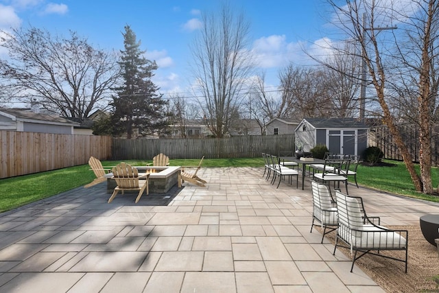 view of patio featuring a storage shed and a fire pit