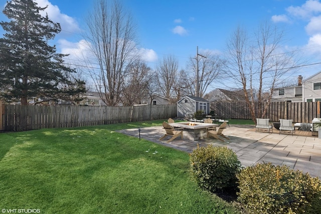 view of yard featuring a storage shed, a patio, and an outdoor fire pit