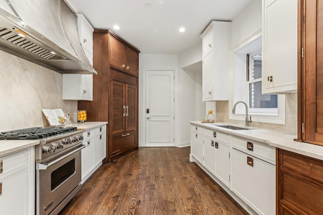 kitchen featuring high end stainless steel range, sink, white cabinetry, dark hardwood / wood-style floors, and custom range hood