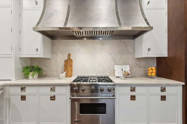 kitchen with white cabinetry, tasteful backsplash, range hood, and designer stove