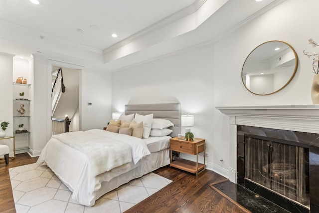 bedroom featuring ornamental molding, a tray ceiling, and hardwood / wood-style floors