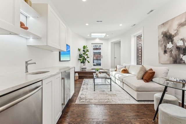 living room with sink, a skylight, and dark hardwood / wood-style floors