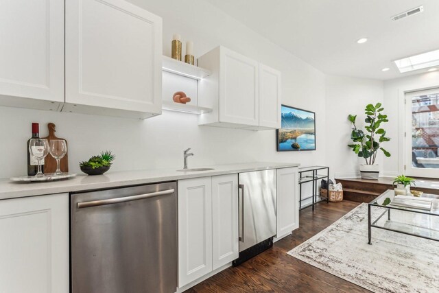 kitchen featuring stainless steel dishwasher, sink, and white cabinets