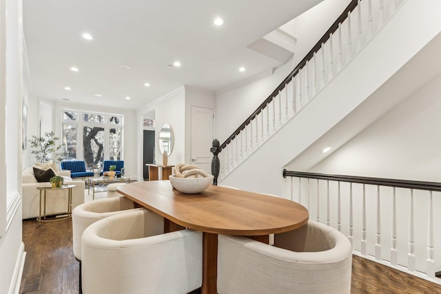 dining room featuring dark wood-type flooring and crown molding