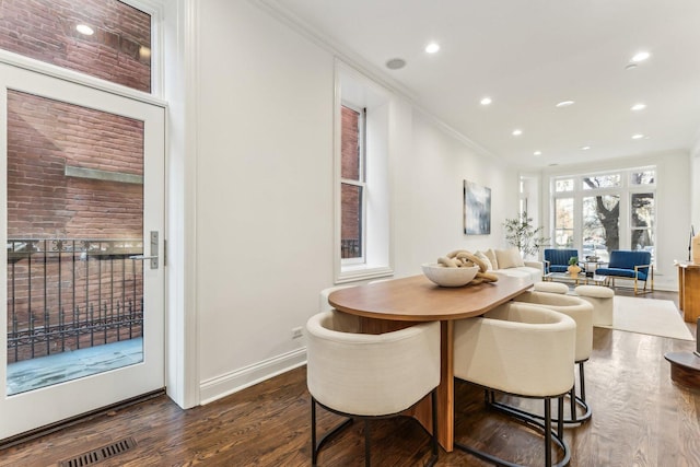 dining area featuring ornamental molding and dark hardwood / wood-style floors