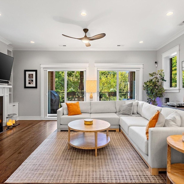 living room with ceiling fan, ornamental molding, and wood-type flooring