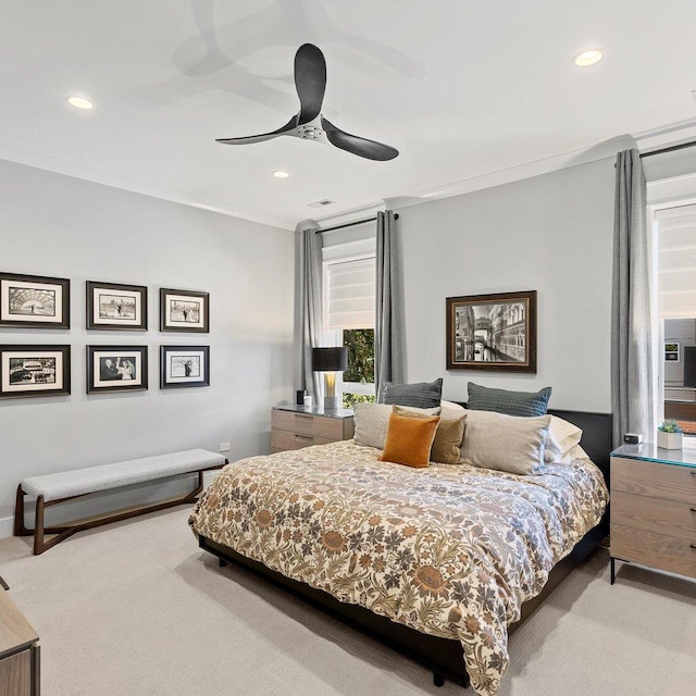 bedroom with light carpet, ornamental molding, and ceiling fan