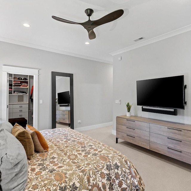 bedroom featuring crown molding, a walk in closet, ceiling fan, a closet, and light colored carpet