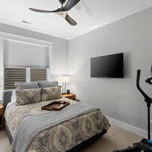 carpeted bedroom featuring ornamental molding and ceiling fan