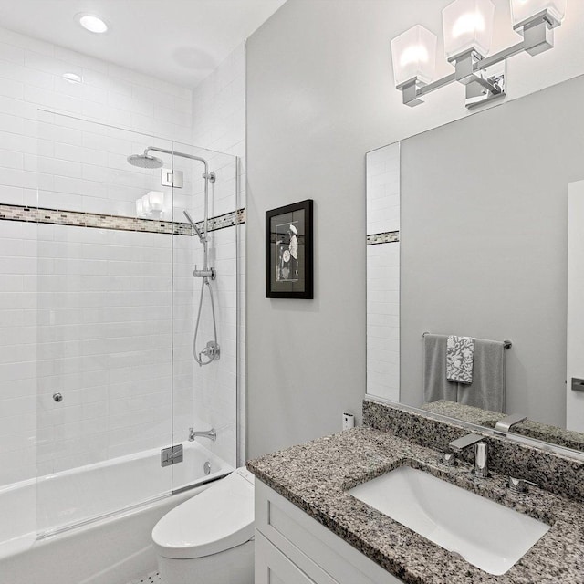 full bathroom featuring tiled shower / bath, vanity, and toilet